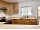 Functional kitchen with light wood cabinets, a stainless steel stove, and a bright window over the sink at 2138 Sw 9Th Rd, Ocala, FL 34471