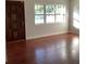 Bright living room featuring beautiful hardwood floors, a wooden front door, and a large window with natural light at 2138 Sw 9Th Rd, Ocala, FL 34471