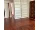 Inviting living room showcasing gleaming hardwood floors, a built-in bookcase, and a solid front door at 2138 Sw 9Th Rd, Ocala, FL 34471