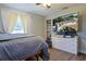 Bedroom featuring large television, window view, hardwood flooring, and comfy bed at 2808 Ne 24Th Ct, Ocala, FL 34470