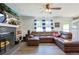 Cozy living room features a fireplace, built-in shelves, a ceiling fan, and a comfortable brown leather couch at 2808 Ne 24Th Ct, Ocala, FL 34470