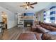 Living room showcases a fireplace, built-in shelves, a ceiling fan, and a brown leather sectional sofa at 2808 Ne 24Th Ct, Ocala, FL 34470