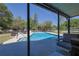Inviting backyard pool with steps and a lounge area surrounded by lush greenery at 2808 Ne 24Th Ct, Ocala, FL 34470