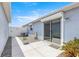 Backyard patio featuring gray siding, sliding glass door, and concrete pavers at 3017 Moultrie Way, The Villages, FL 32162