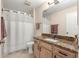 Bathroom featuring a granite countertop vanity, shower and soft neutral color walls at 3017 Moultrie Way, The Villages, FL 32162
