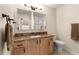 Bathroom featuring a granite countertop vanity, framed mirror, and soft neutral walls at 3017 Moultrie Way, The Villages, FL 32162