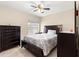 Cozy bedroom with neutral color walls, tile floors, ceiling fan and dresser at 3017 Moultrie Way, The Villages, FL 32162