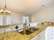 Kitchen featuring granite countertops, tiled backsplash, stainless steel sink, and white cabinets at 5327 Sw 89Th St, Ocala, FL 34476