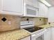 Close up of kitchen featuring granite countertops, tile backsplash, and stainless steel range at 5327 Sw 89Th St, Ocala, FL 34476