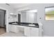 Bright bathroom featuring double sinks, a dark countertop, and a large mirror at 5331 Old Hickory Ln, Fruitland Park, FL 34731