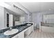 This updated bathroom has dual sinks, a marble countertop, and a bathtub for relaxing at 5331 Old Hickory Ln, Fruitland Park, FL 34731
