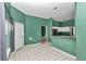Green-walled kitchen with white cabinets, breakfast bar, and tile flooring at 5331 Old Hickory Ln, Fruitland Park, FL 34731