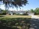 Lovely exterior view of single-story home with mature trees, manicured lawn and a side entry garage at 5355 Sw 31St St, Ocala, FL 34474