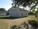 Exterior of garage, featuring a roll up door, and a lawn area at 5355 Sw 31St St, Ocala, FL 34474