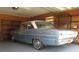 View of a vintage blue and white car stored in a well-organized garage with shelving at 5355 Sw 31St St, Ocala, FL 34474