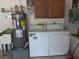 Complete laundry room with washer, dryer, water heater, and sink in a functional layout at 5355 Sw 31St St, Ocala, FL 34474