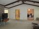 Bright living room featuring exposed beams, fireplace, and views to the dining room and entryway at 5355 Sw 31St St, Ocala, FL 34474