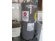 A gray Rheem water heater with a warning sticker installed next to a white laundry sink at 5355 Sw 31St St, Ocala, FL 34474