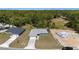 An aerial view of a newly constructed home with lush green landscaping and a long drive way at 6756 Sw 151St Loop, Ocala, FL 34473