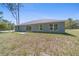 View of the backyard of this charming home, featuring a grassy lot and space for your vision at 6756 Sw 151St Loop, Ocala, FL 34473