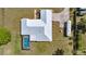 Aerial view of a modern home with a pristine white roof, swimming pool, and well-kept landscaping at 719 Ne 39Th St, Ocala, FL 34479