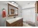 Bathroom featuring wood vanity, stylish fixtures, and a shower with a decorative curtain, providing a functional space at 719 Ne 39Th St, Ocala, FL 34479