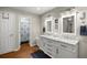 Bright bathroom featuring double sinks with marble countertops, modern fixtures, and a separate shower area at 719 Ne 39Th St, Ocala, FL 34479