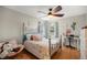 Bright bedroom featuring a metal frame bed, a ceiling fan, and a white desk and dresser, perfect for a space at 719 Ne 39Th St, Ocala, FL 34479