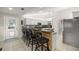 Charming kitchen featuring a breakfast bar with seating, white cabinetry, and stainless steel appliances at 719 Ne 39Th St, Ocala, FL 34479