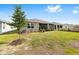 Backyard shows well-maintained lawn, screened patio, and young tree with fresh mulch at 8090 Penrose Pl, Wildwood, FL 34785