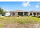 Backyard with green lawn provides shade, colorful plants and access to screened-in patio at 8090 Penrose Pl, Wildwood, FL 34785