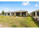 Backyard showcases lush green lawn, stone border, and a screened-in patio at 8090 Penrose Pl, Wildwood, FL 34785