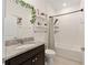 Bathroom featuring granite counters, dark vanity, tub, shower and decorative shelves at 8090 Penrose Pl, Wildwood, FL 34785