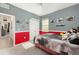 The secondary bedroom includes a ceiling fan, nice trim, and bright red accent wall at 8090 Penrose Pl, Wildwood, FL 34785