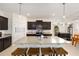 Modern kitchen features dark cabinets, granite countertops, an island with seating, and stylish pendant lighting at 8090 Penrose Pl, Wildwood, FL 34785