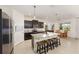 Contemporary kitchen boasts dark cabinetry, granite countertops, a central island with seating, and stainless steel appliances at 8090 Penrose Pl, Wildwood, FL 34785