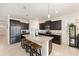 Modern kitchen with granite countertops, dark cabinetry and seating for four at the kitchen island at 8090 Penrose Pl, Wildwood, FL 34785