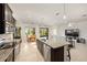 Open-concept kitchen boasts dark cabinets, granite countertops, a dining area, and a view into the living room at 8090 Penrose Pl, Wildwood, FL 34785