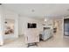 Bright living room featuring neutral walls, tile floors, and comfortable seating around a large screen TV at 8090 Penrose Pl, Wildwood, FL 34785