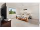 Serene bedroom with a large window, ceiling fan, neutral walls, and a comfortable bed with decorative pillows at 8090 Penrose Pl, Wildwood, FL 34785