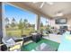 Screened in patio with cozy seating and view of the green backyard at 8090 Penrose Pl, Wildwood, FL 34785