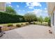 Large brick paver patio with manicured hedges and landscaping for outdoor entertaining at 8955 Sw 86Th Loop, Ocala, FL 34481