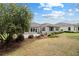 Wide angle shot of a green backyard featuring a patio and various shrubs and trees at 8955 Sw 86Th Loop, Ocala, FL 34481