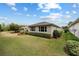 Wide backyard view featuring a green lawn, landscaping, and an extended patio with sunroom at 8955 Sw 86Th Loop, Ocala, FL 34481
