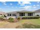 Backyard featuring a green lawn, shrubs and a patio with a sunroom at 8955 Sw 86Th Loop, Ocala, FL 34481