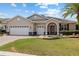 Charming single-story home featuring a well-manicured lawn, archway entrance, and three-car garage at 8955 Sw 86Th Loop, Ocala, FL 34481