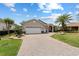 Well maintained home featuring a large driveway, manicured lawn, and mature landscaping at 8955 Sw 86Th Loop, Ocala, FL 34481