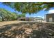 Expansive backyard with mature trees, the back of the home, and an outdoor structure at 9885 Se 144Th St, Summerfield, FL 34491