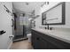 Bathroom featuring a glass shower with matte black hardware, handrails, and modern vanity at 9885 Se 144Th St, Summerfield, FL 34491