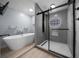 Stylish bathroom featuring a modern shower and standalone tub, complemented by wood-look floors and contemporary fixtures at 9885 Se 144Th St, Summerfield, FL 34491
